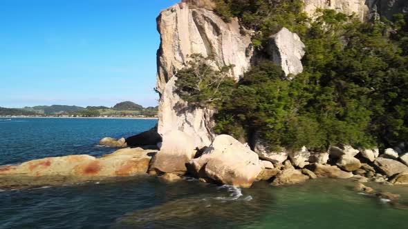 Revealing from behind limestone cliffs to a bay in the Coromandel Peninsula