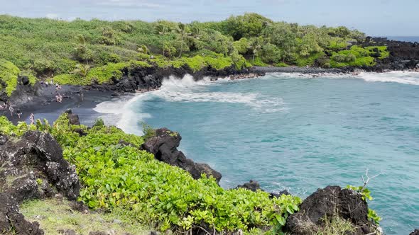 A scenic, picturesque view of a Hawaiian black sand beach coastline. Along the Road to Hana.