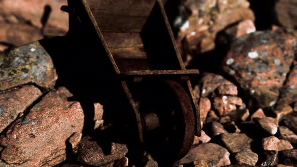 Abandoned Wooden Mine Wheelbarrow on Rocks alt