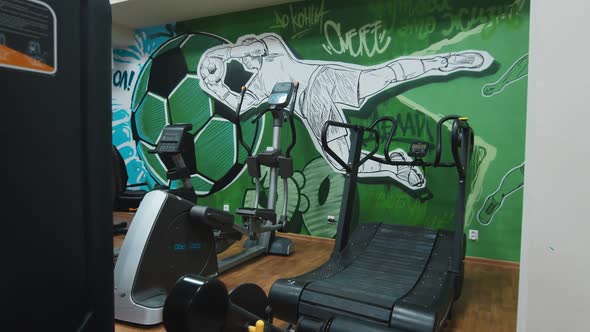 Training Machines By Wall with Football Decor in Gym