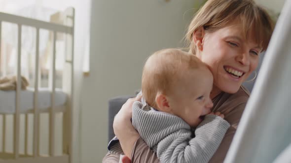 Loving Mom Hugging Happy Baby