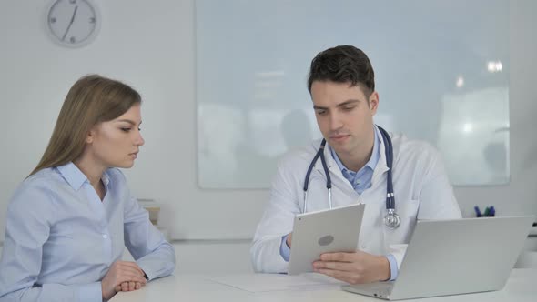 Patient Having Consultation with Doctor, Using Tablet in Clinic