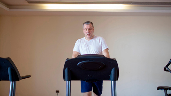 Middle-Aged Man Working Out on A Treadmill