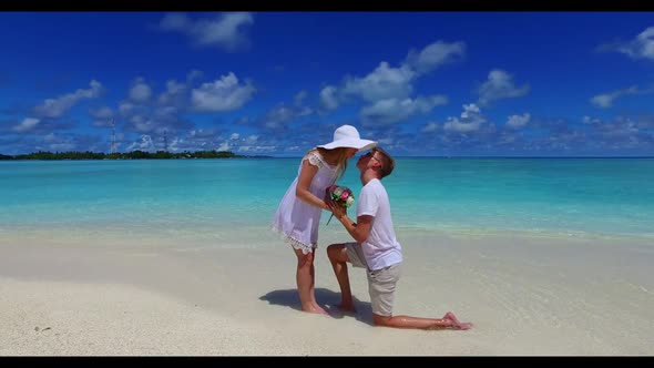 Man and woman happy together on tropical shore beach holiday by turquoise lagoon with white sand bac