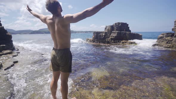 Freedom man opens his arms in the sea.