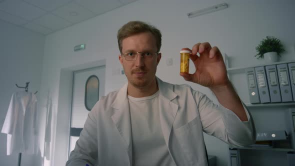 Therapist Holding Pill Bottle at Online Consultation in Health Clinic Close Up