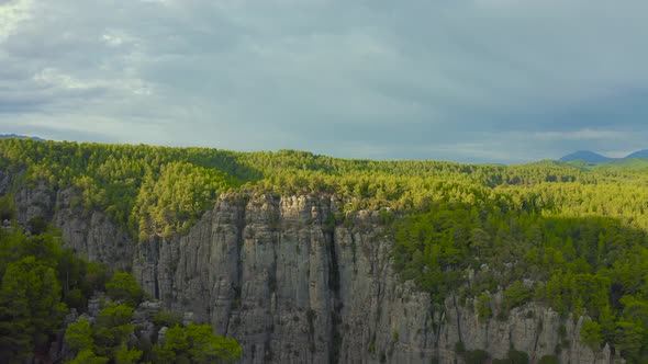 A man and a woman are sitting on the edge of the Tazy canyon in National Park on Manavgat