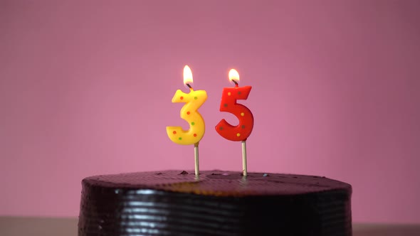 Chocolate Birthday Cake with Wick Lighting Trying to Blowout Candle