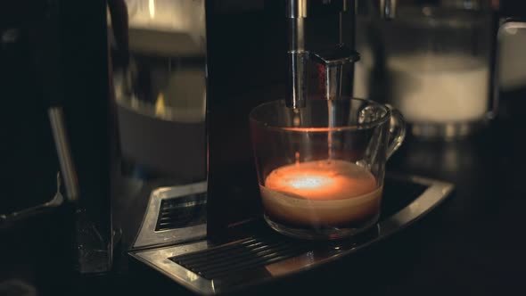 Coffee From Espresso Machine Dripping Into Clear Cup