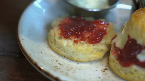 tasty scone with strawberry jam and fresh cream