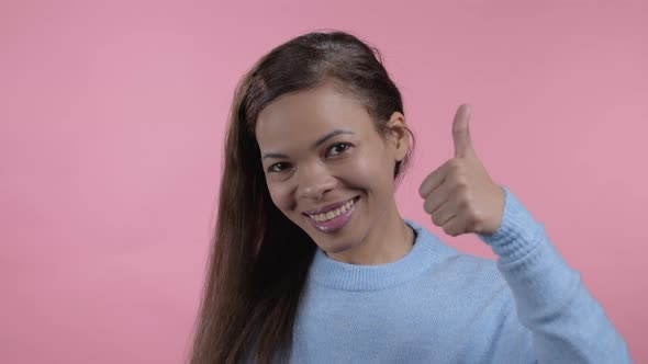 African Woman Showing Thumb Up Sign on Pink Background