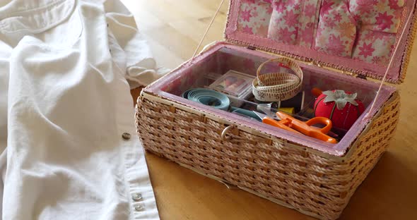 A sewing kit with pin cushion, tape measures, needle and thread on a table for a seamstress to repai