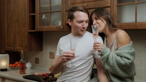 Romantic Young Couple That Enjoys a Glass of Wine and Relaxing in Kitchen