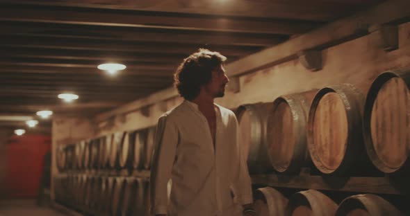 Man walks inbetween Wine barrels