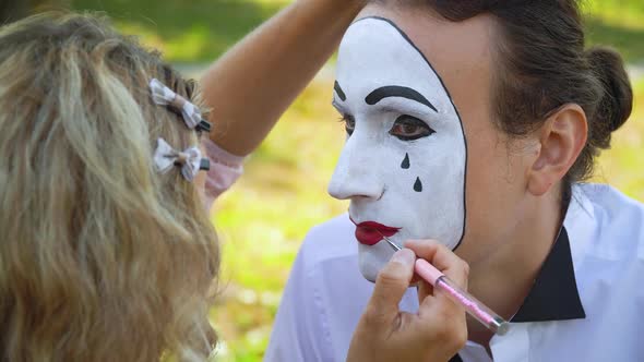 Girl Paint Lips To Man Mime with Red Pencil