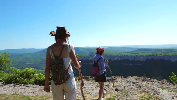 Two Girls Traveler Girlfriend Walk on a Mountain Plateau and Admire the Amazing Views