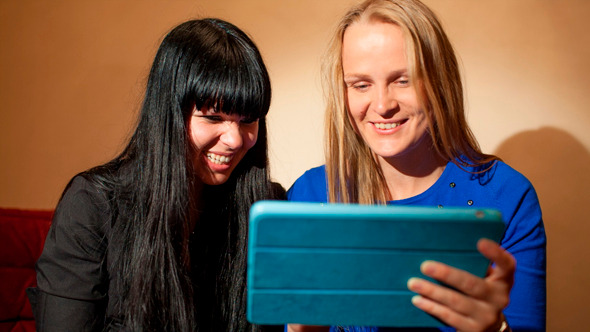 Two Young Woman Reading A Tablet-Pc