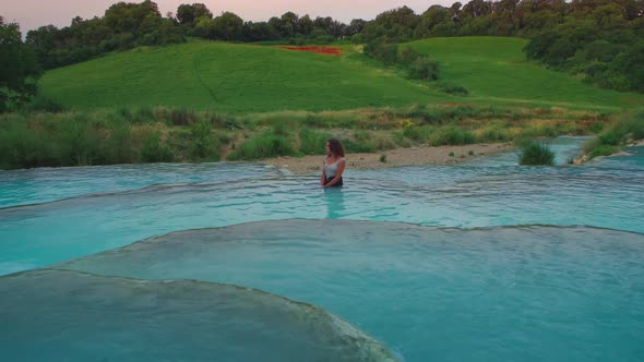 4K UHD Cinemagraph / seamless video loop of a young woman relaxing in  thermal hot springs basin in