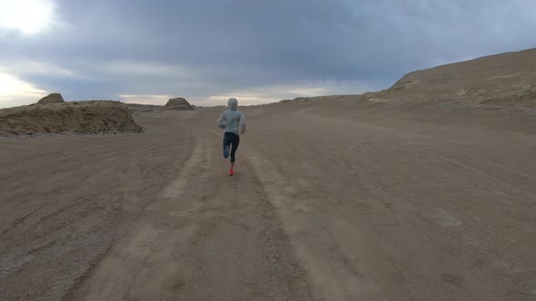 Fitness woman trail runner cross country running on sand desert dunes