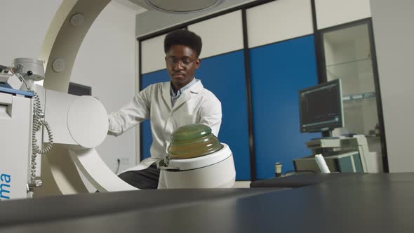 Bottom View of Young Confident African Doctor in White Uniform Working with