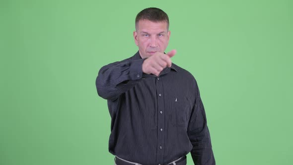 Angry Macho Mature Businessman with Threat Gesture