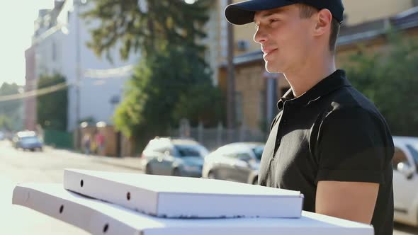 Pizza Delivery. Courier Delivering Box With Food To Client