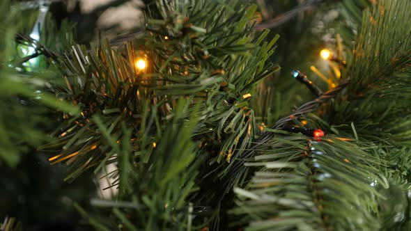 Hidden fairy lights on garlande close-up 4K 2160p 30fps UHD footage - Beautiful  Christmas tree colo