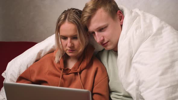 Caucasian Couple Using Laptop at Home
