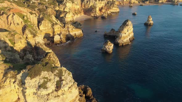 Algarve, Portugal. Flying Over Turquoise Waters of Atlantic Ocean and Yellow Rocks on the Coast