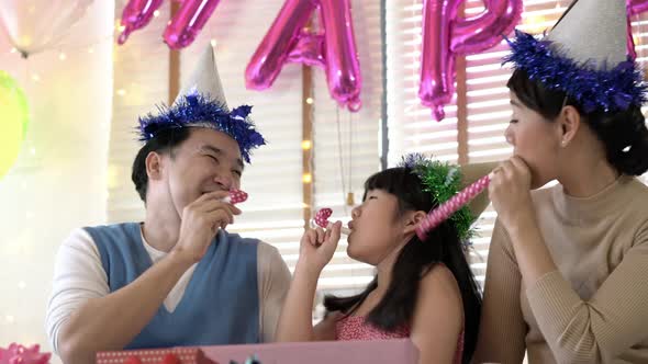 Father and mother with daughter enjoy in birthday party