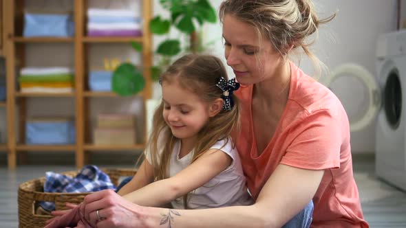 Mom and Cute Kid Daughter Hug While Folding Laundry Together Spbd