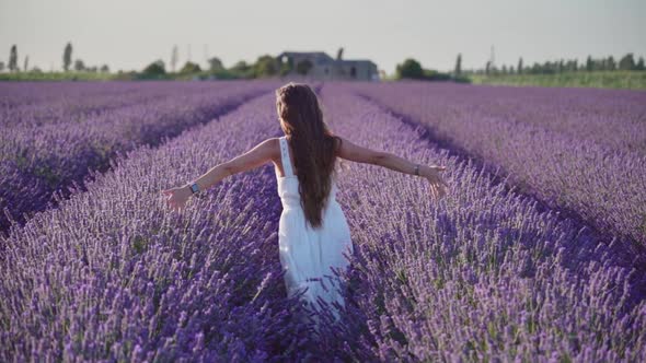 Girl with Open Arms in Slow Motion Among Purple Lavender