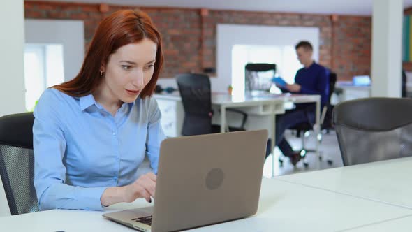 Businesswoman with Red Hair Raising Hands