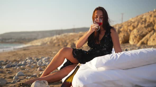 Wide Shot of Relaxed Elegant Young Caucasian Woman Degustating Expensive Red Wine Sitting on