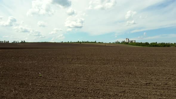 Aerial Drone View Flight Over Huge Plowed Field and Blue Sky