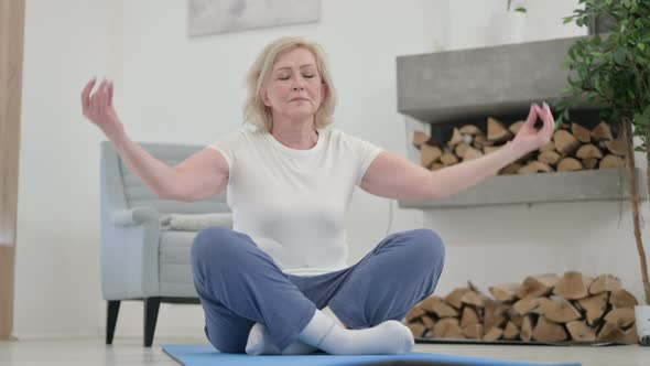 Healthy Senior Old Woman Meditating on Yoga Mat at Home