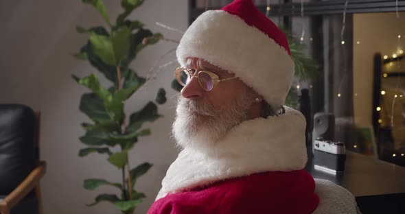 Closeup Portrait of a Pensive Santa Claus Looking Thoughtfully in Front of Him Then at the Camera