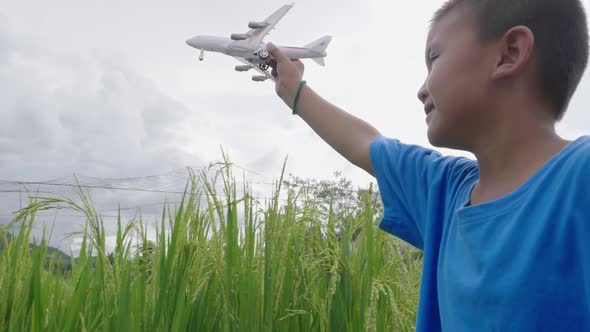 Asian Boy Walking With Airplane