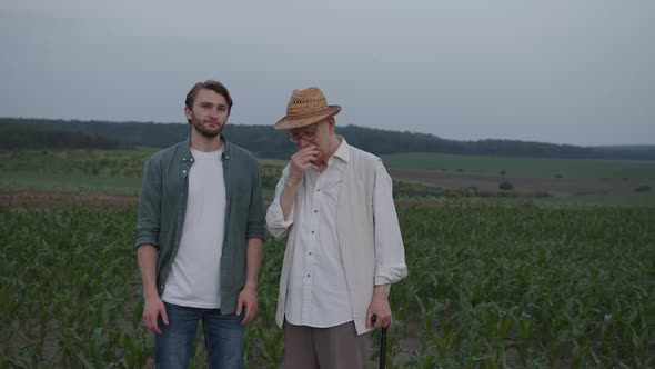 Young and Old Farmers Stand and Talk