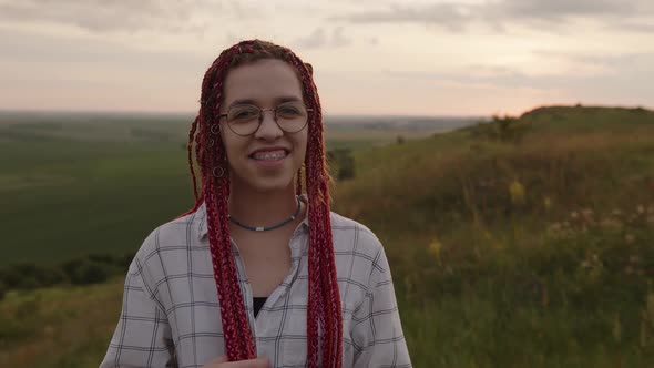 Close Up View of a Girl That Smiles and Touches Her Red Hair