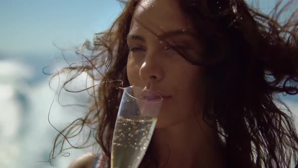 Portrait of Pretty Long Haired Brunette Relaxing on Boat Drinking Champagne Enjoying Splendid Time