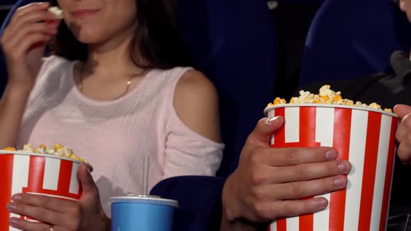 Man and Woman Eating Popcorn at the Cinema