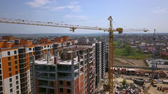 Aerial view of high modern residential building and tower crane under construction.