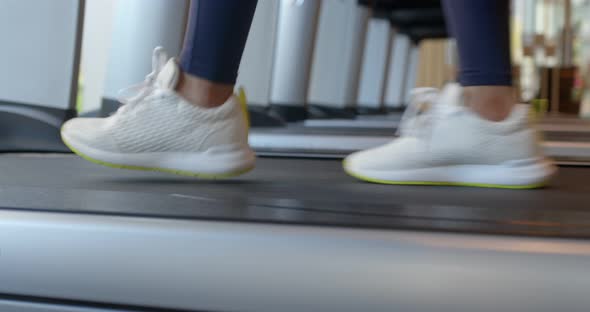 Woman legs run on the treadmill in gym room