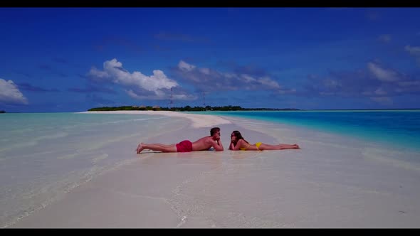 Family of two engaged on exotic bay beach trip by blue green water with white sand background of the