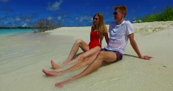 Beautiful boy and girl on romantic honeymoon live the dream on beach on white sand background 