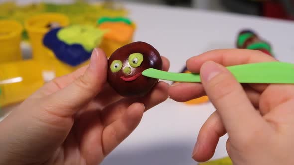 A Woman Creates a Muzzle From Dough for Sculpting on Chestnut for Handicraft Caterpillars