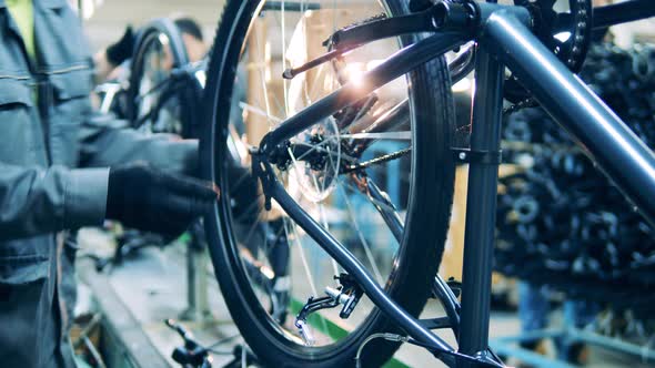 A Bike Is Getting Fabricated and Adjusted By a Worker
