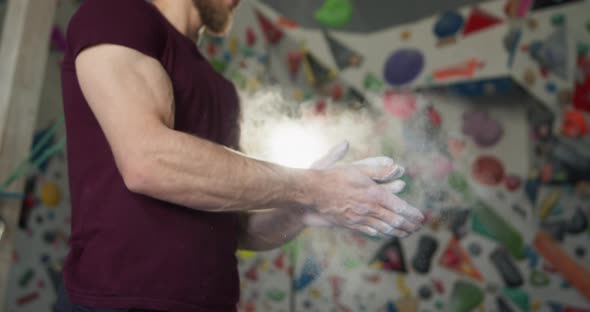 Young Bearded Athlete Clapping Hands with Chalk Powder Preparing for Training