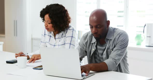 Man using laptop while woman calculating bills 4k